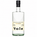 A bottle of Yola Pechuga agave spirit, featuring a clear glass bottle with a cream-colored label and a black cap, set against a plain white background.